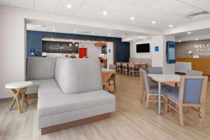 a living room with a couch and tables and chairs at Hampton Inn Bellingham Airport, WA in Bellingham