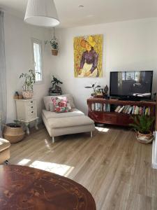 ein Wohnzimmer mit einem Sofa und einem TV in der Unterkunft דירה נעימה ומפנקת באזור יפו in Tel Aviv