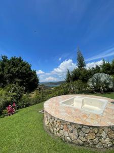 a hot tub in a stone circle in the grass at Finca Colonial / Lago Calima in Calima