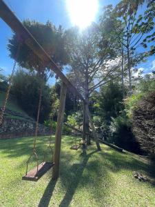 a swing set in a yard with the sun behind it at Finca Colonial / Lago Calima in Calima