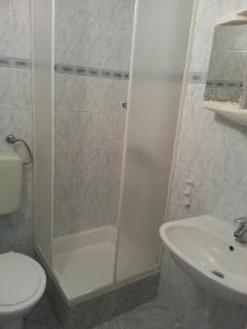 een badkamer met een douche, een toilet en een wastafel bij Školjka 5 in Crikvenica