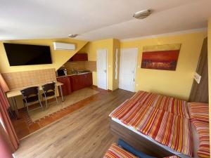 ein Wohnzimmer mit einem Bett und eine Küche mit einer Theke in der Unterkunft Vanessza apartman in Siófok