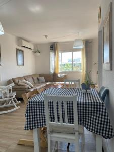 ein Wohnzimmer mit einem Tisch, Stühlen und einem Sofa in der Unterkunft דירה נעימה ומפנקת באזור יפו in Tel Aviv