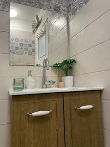 a bathroom counter with a sink and a mirror at דירה נעימה ומפנקת באזור יפו in Tel Aviv