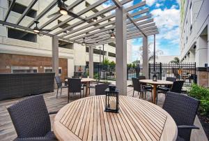 um pátio exterior com mesas, cadeiras e toldos em Home2 Suites by Hilton Houston Medical Center, TX em Houston