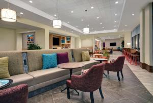 a lobby with a couch and tables and chairs at Home2 Suites by Hilton Houston Medical Center, TX in Houston