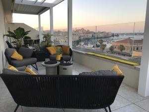 a balcony with chairs and a view of a city at LA TERRAZZA SUL PORTO in Syracuse