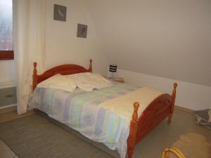 um quarto com uma cama com uma cabeceira de madeira em Bel appartement de charme de 70 m2 em Thannenkirch