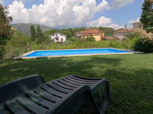 un banco sentado en el césped junto a una piscina en B&B il Feudo en Fontechiari
