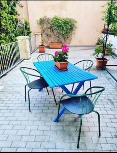 a blue picnic table with two chairs and a potted plant at Casa Pellico in Turin