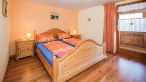 een slaapkamer met een houten bed met 2 kussens bij Ferienhaus Sommer in Pfronten