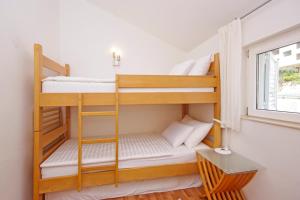 2 Etagenbetten in einem kleinen Zimmer mit Fenster in der Unterkunft NEVA in Makarska