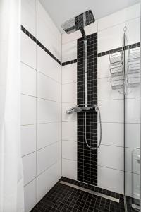 y baño con ducha y azulejos blancos y negros. en Ferienwohnung Suhl/ Wichtshausen, en Suhl