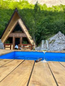 a glass of wine on a table in front of a cabin at Etno Cottages Komarnica Authentic Peaceful Mountain Getaway in Šavnik +47 photos