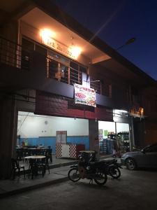 a motorcycle parked in front of a building at night at The Second Room in Ranau