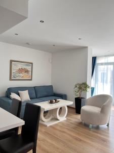 a living room with a blue couch and a table at Villa Milan in Sveti Stefan