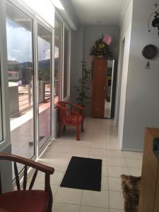a living room with a red chair and a balcony at The Second Room in Ranau