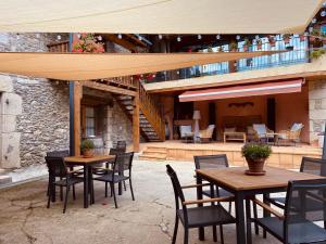 a patio with wooden tables and chairs and a building at Aparthotel les Corts in Llivia