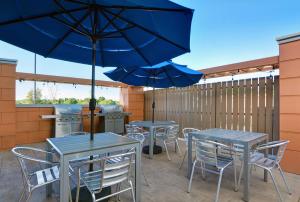 two tables and chairs with umbrellas on a patio at Home2 Suites By Hilton Bentonville Rogers in Bentonville