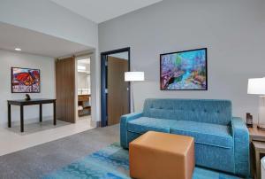 sala de estar con sofá azul y mesa en Home2 Suites By Hilton Bentonville Rogers, en Bentonville