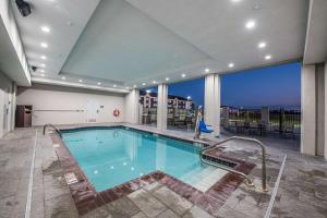 a swimming pool in a building with a large window at Doubletree Sulphur Lake Charles in Sulphur