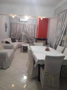 une salle à manger avec des tables et des chaises blanches dans l'établissement Deluxe Sophia`s Penthouse Apartment, à Karpathos