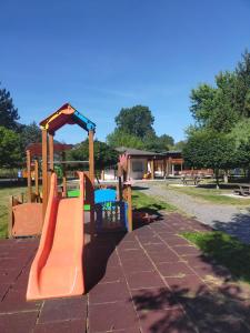 einen Spielplatz mit einer orangenen Rutsche in einem Park in der Unterkunft Casa Grazia in Lovero Valtellino