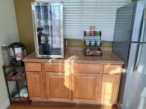 a counter in a kitchen with a refrigerator at Rodeway Inn Downtown Hanford in Hanford