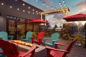 un patio con sillas coloridas y una hoguera en Home2 Suites By Hilton Bend, Or en Bend