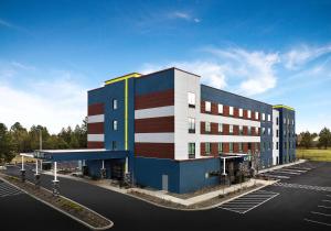 本德Home2 Suites By Hilton Bend, Or的停车场内建筑物的 ⁇ 染