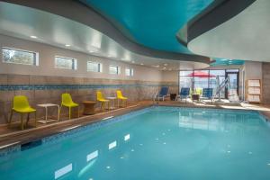 uma piscina num hotel com cadeiras e mesas amarelas em Home2 Suites By Hilton Bend, Or em Bend