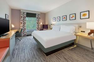 a hotel room with a large bed and a flat screen tv at Hilton Garden Inn Columbus Easton, Oh in Columbus