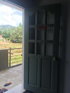 an open door with a view of a field at The Second Room in Ranau