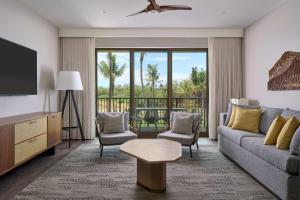 Hilton Grand Vacations Club Maui Bay Villas في كيهي: غرفة معيشة مع أريكة وتلفزيون