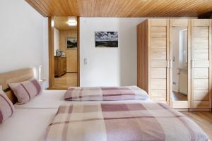 a bedroom with a large white bed and wooden ceilings at Haus Fritz in Wittenschwand