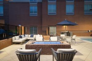 グリアにあるHampton Inn Greer Greenville, Scのテーブルと椅子と傘のあるパティオ