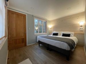 a bedroom with a large bed and a window at Hostal Boutique Puerta Roja in Punta Arenas