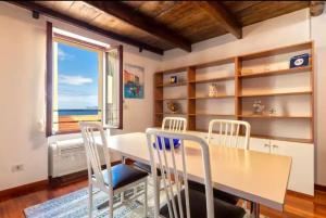 comedor con mesa, sillas y ventana en Apartment Cavour, en Alghero