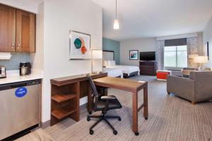 une chambre d'hôtel avec un bureau et une chambre dans l'établissement Homewood Suites By Hilton Columbus Easton, Oh, à Columbus