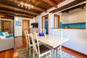 cocina y comedor con mesa y sillas en Apartment Cavour, en Alghero