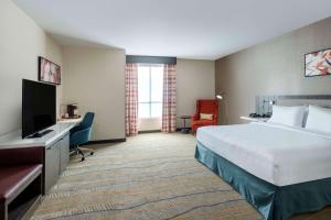 a hotel room with a bed and a flat screen tv at Hilton Garden Inn Pomona, CA in Pomona