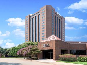 a brick building with a hilton sign in front of it at Hilton Richardson Dallas, TX in Richardson