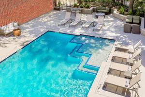 a large swimming pool with chairs and a table at Hilton Richardson Dallas, TX in Richardson