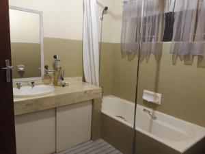 a bathroom with a sink and a tub and a shower at Die Plasie on-suite rooms in Hartbeespoort +21 photos