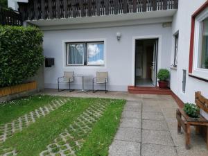 a house with two chairs and a table in the yard at Apartments Rauter in Annenheim