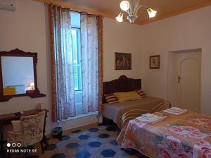 sypialnia z 2 łóżkami i oknem w obiekcie Angelina Antica Dimora w mieście Terracina