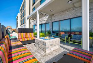 a patio with chairs and a fire pit on a building at Home2 Suites By Hilton Whitestown Indianapolis Nw in Whitestown