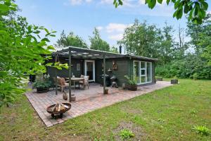 een klein groen huisje met een patio en een tafel bij Lovely Holiday Home On Djursland in Ebeltoft