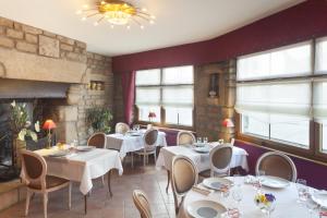a restaurant with white tables and chairs and windows at Au Relais du Porhoet in Guilliers +26 photos
