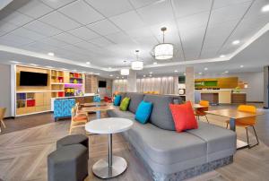 un soggiorno con divano, tavolo e sedie di Home2 Suites By Hilton Whitestown Indianapolis Nw a Whitestown